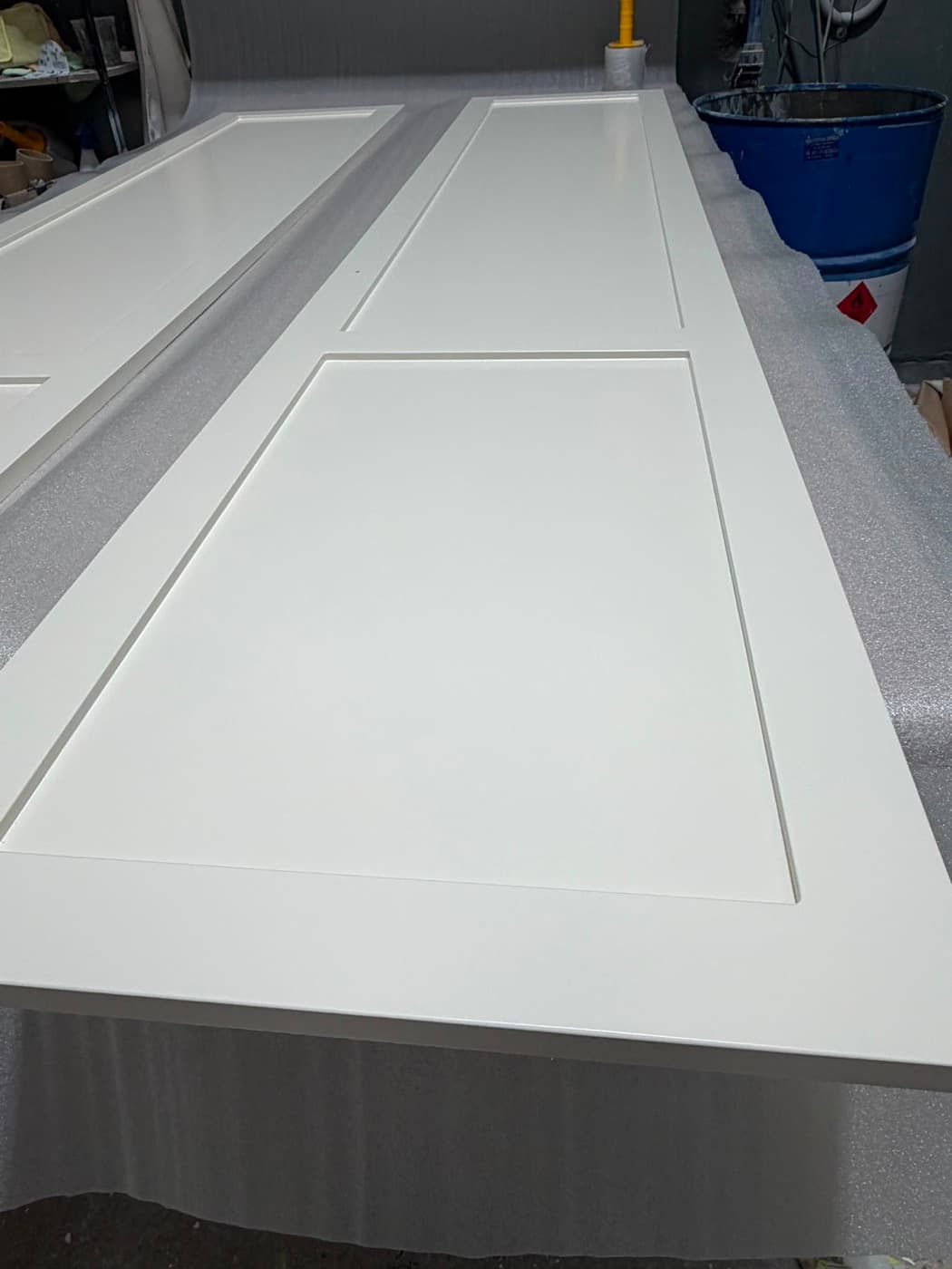 White 2-pac finished doors on a factory drying rack
